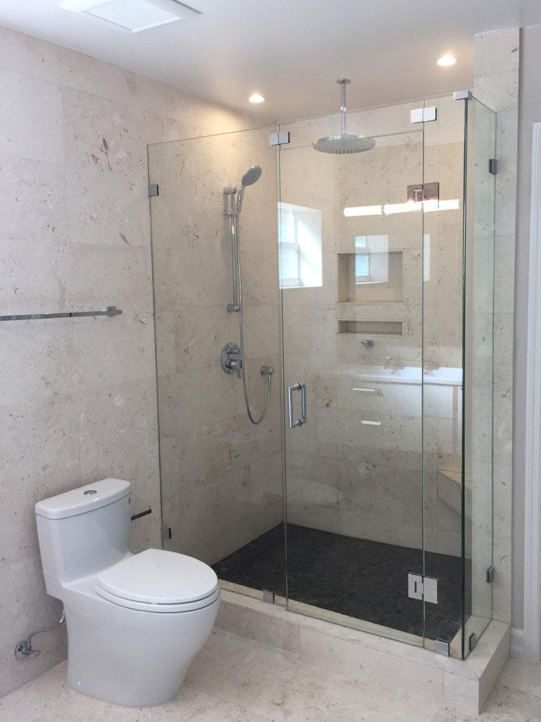 Travertine wall tile & frameless glass enclosure