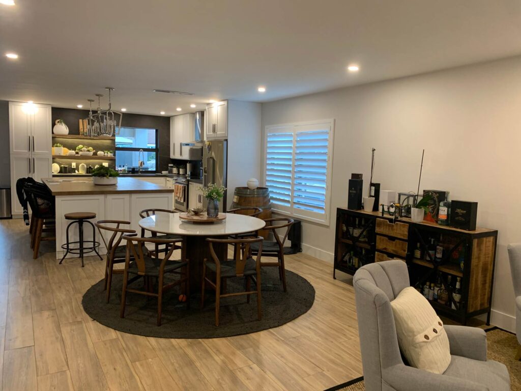 Dining area with porcelain plank floors and kitchen in background