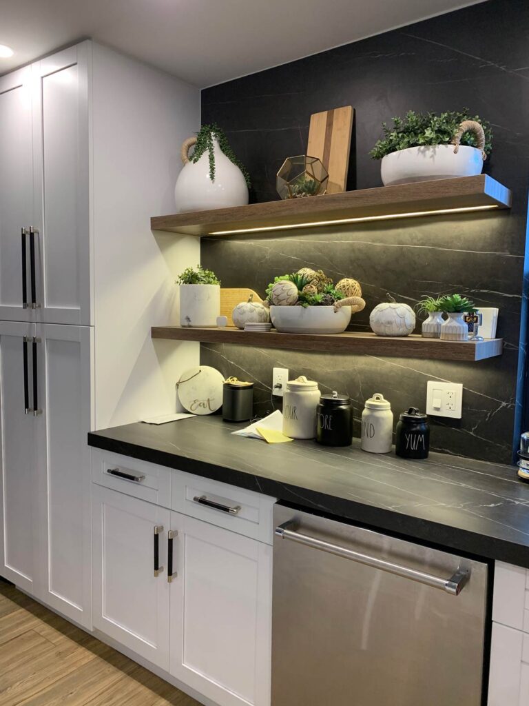 Floating shelves on black porcelain backsplash in kitchen