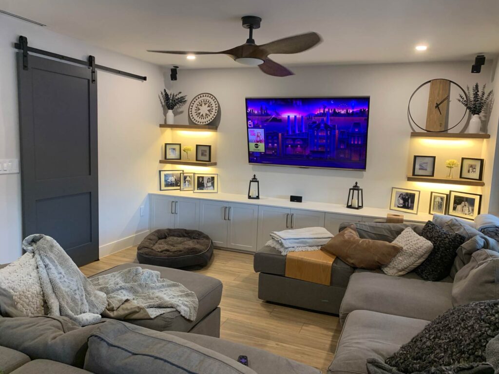 Family room with white shaker cabinetry, floating shelves and wall mounted TV