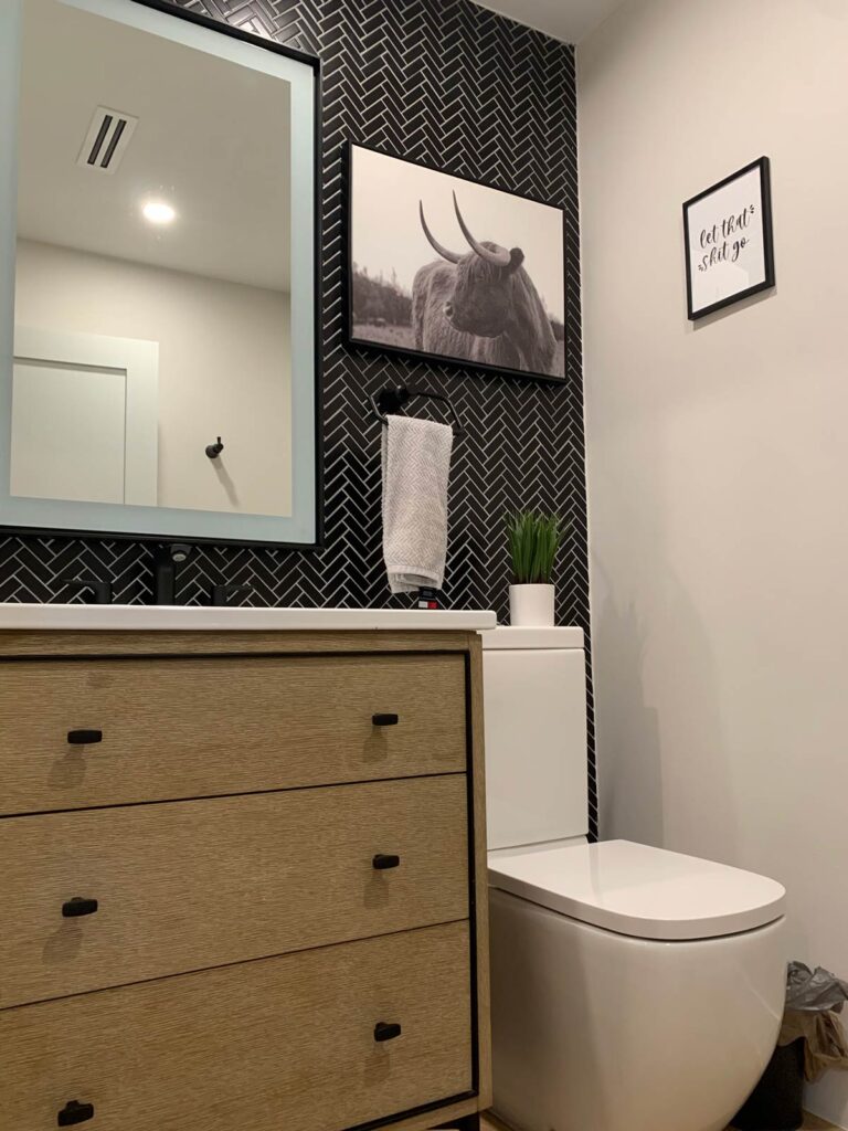 Guest bathroom features a black tile installed in herringbone pattern