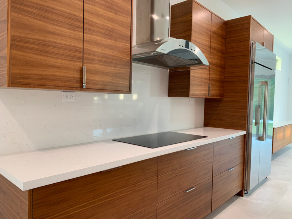 Closeup of perimeter cabinets, cooktop and vent hood.