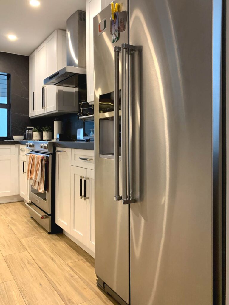 Refrigerator, range and range hood installed along perimeter cabinets