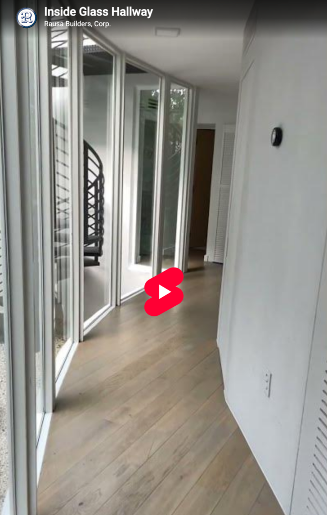 Video of glass hallway walk-through with addition to the right and ground floor patio to the left.